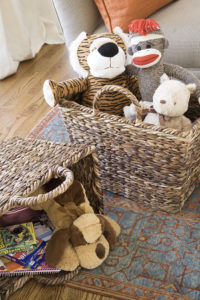 Tall baskets with handles holding toys