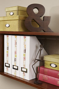decorative boxes and magazine holders on a wall mounted shelf