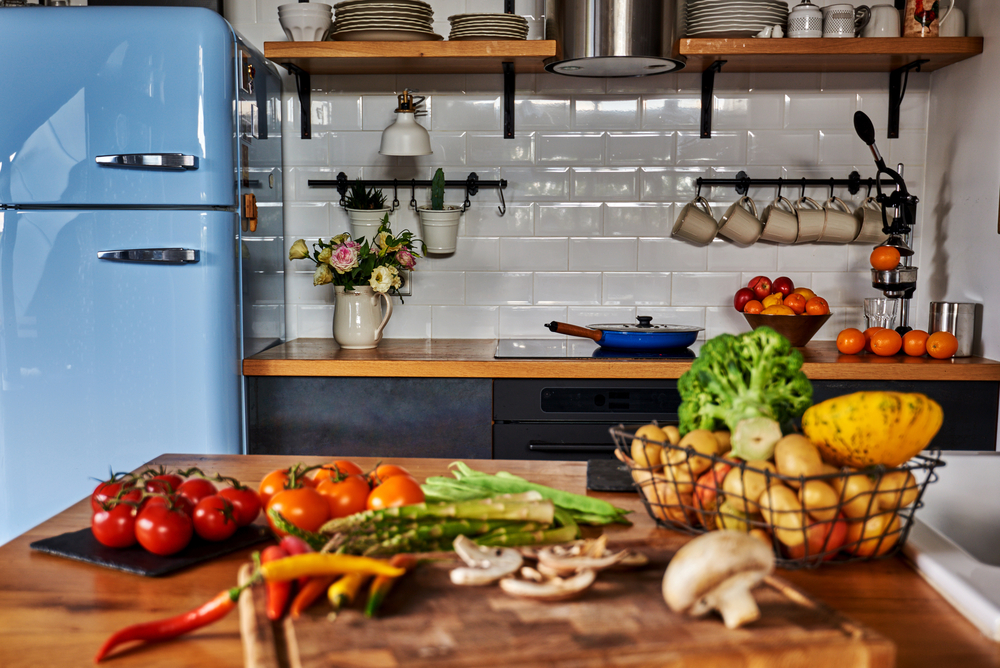Retro kitchen with blue fridge and colorful veggies